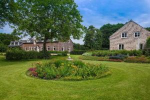 Voortuin voorzien van gras en veel bloemen