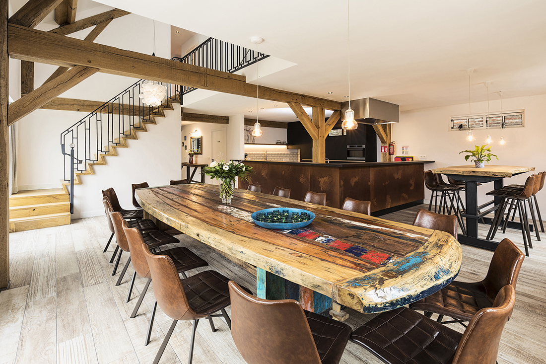 afbeelding: houten tafel met 20 leren stoelen